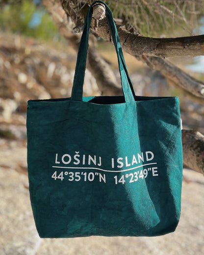 Oversized cotton canvas shopper bag in botanical green with white screen printed Lošinj Island coordinates design on one side.