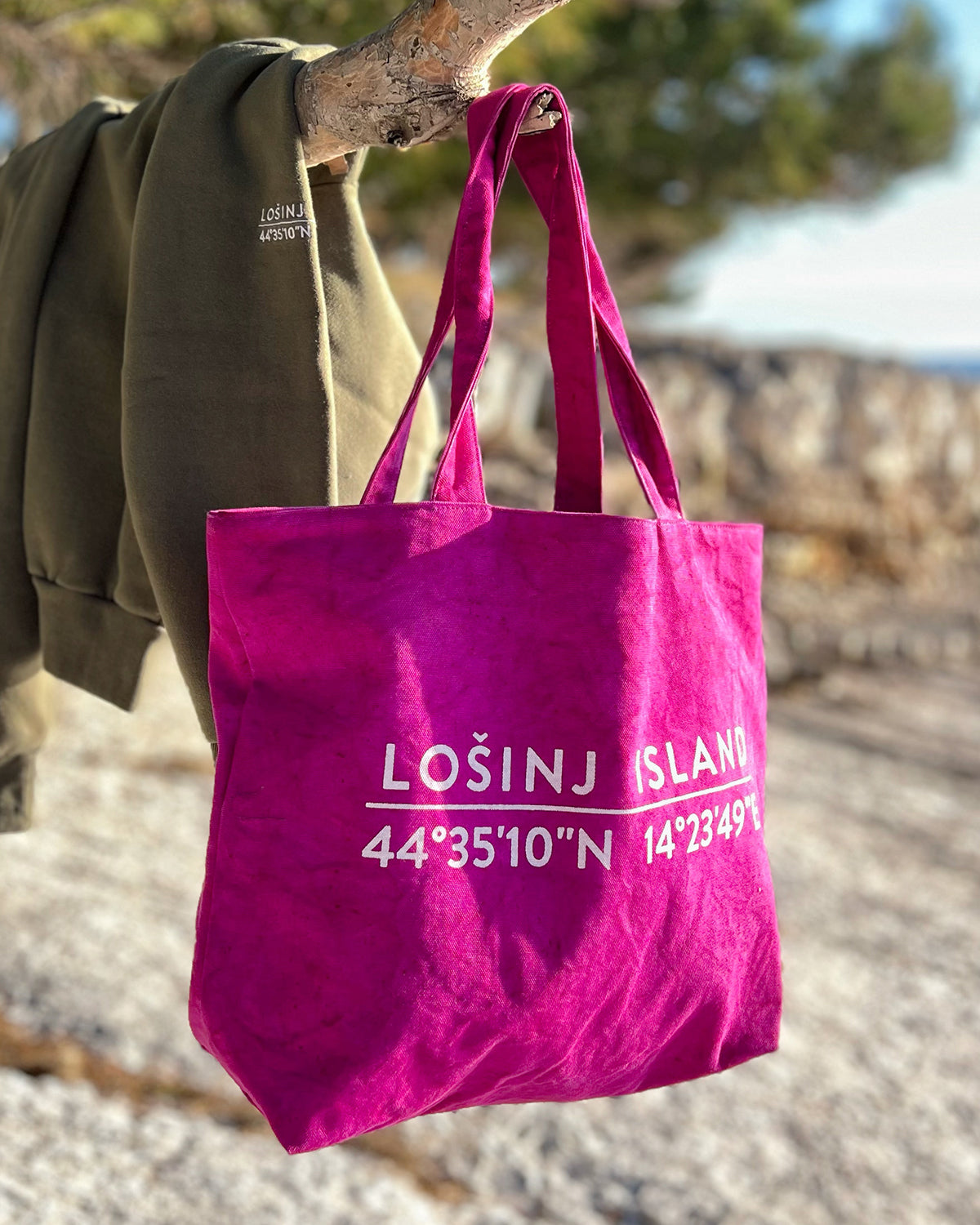 Oversized cotton canvas shopper bag in pink with white screen printed Lošinj Island coordinates design on one side.