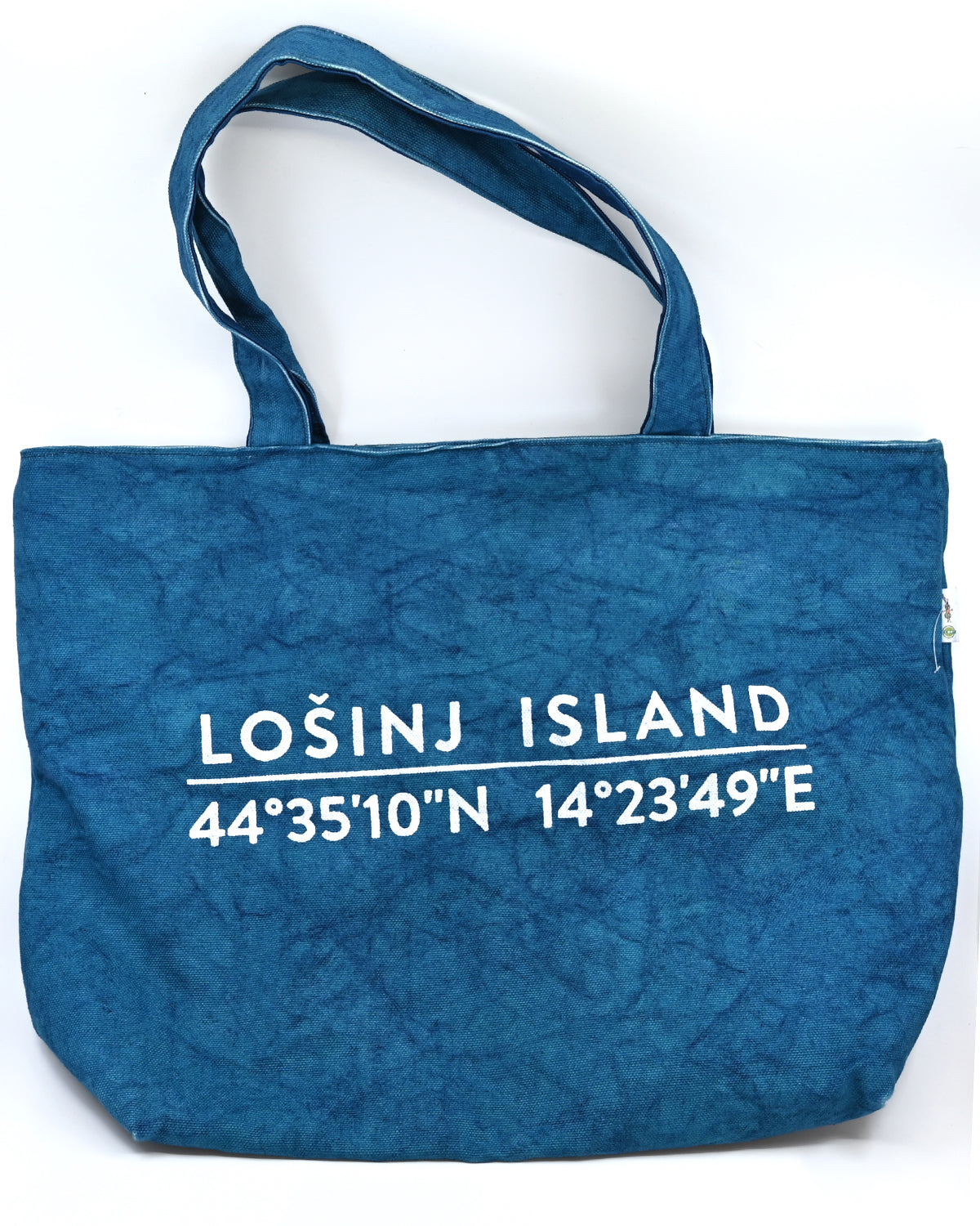 Oversized cotton canvas shopper bag in teal with white screen printed Lošinj Island coordinates design on one side.