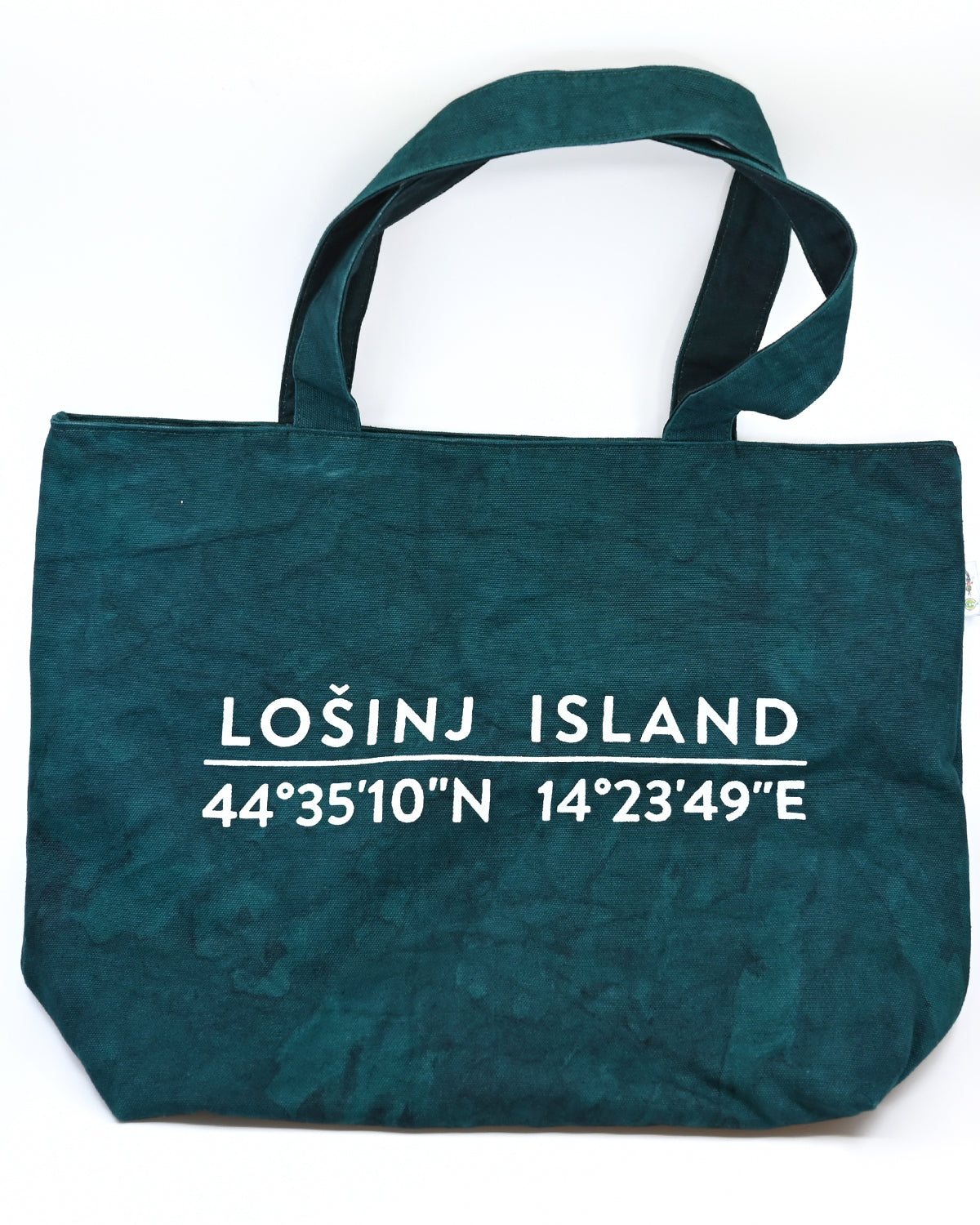 Oversized cotton canvas shopper bag in botanical green with white screen printed Lošinj Island coordinates design on one side.
