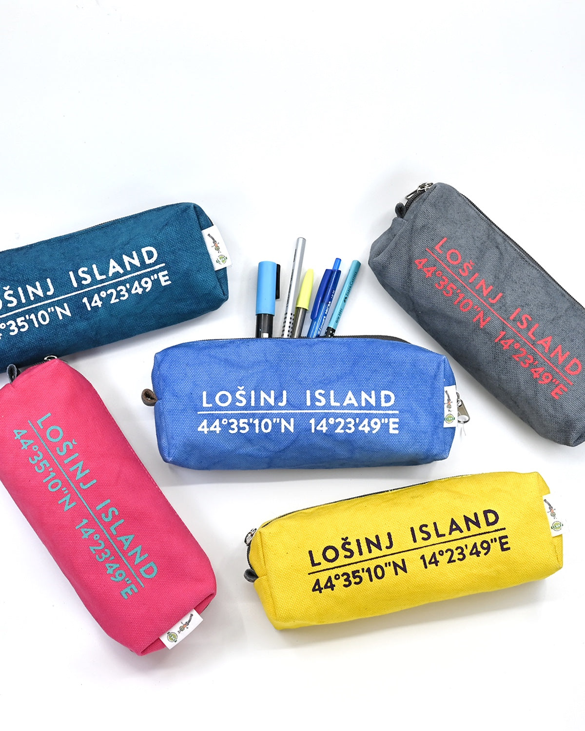 Box-shaped cotton canvas pencil cases in pink, teal, grey, yellow and sky blue. All with splash-proof lining and Lošinj Island coordinates design on one side.