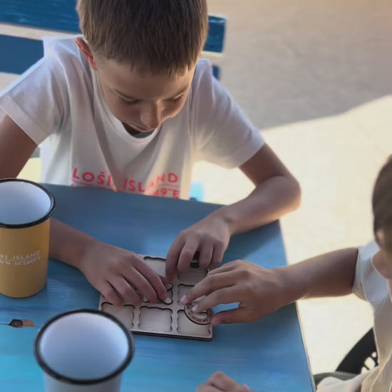 Video of two boys playing the wooden tic tac toe game with engraved Lošinj Island coordinates and Bongolala details.